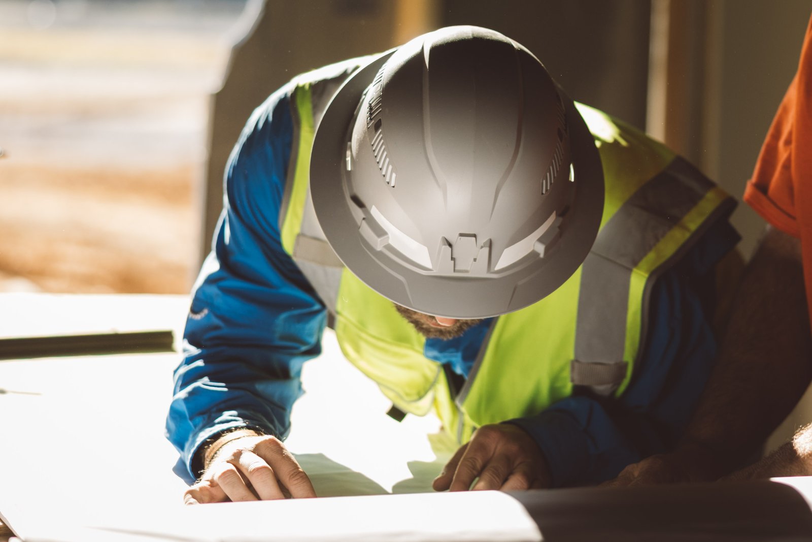 Construction professional studying blueprints in the field